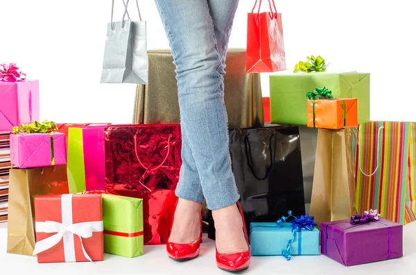 Mulher em pé diante de muitos presentes e sacos de compras — Fotografia de Stock