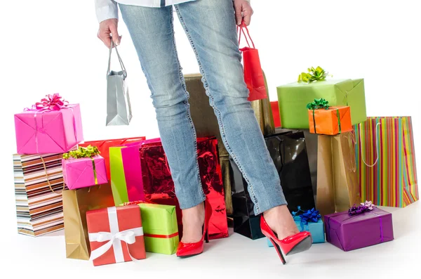 Mujer de pie delante de muchos regalos y bolsas de compras — Foto de Stock