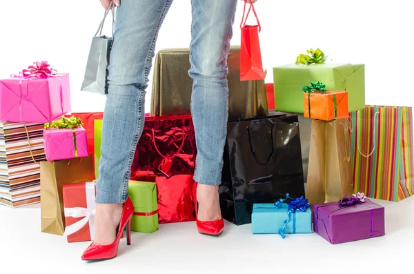 Mujer de pie delante de muchos regalos y bolsas de compras — Foto de Stock