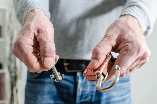 Hombre sosteniendo un candado y una llave —  Fotos de Stock