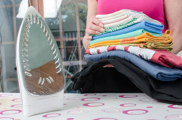 Frau hält gebügelte Wäsche in der Hand — Stockfoto