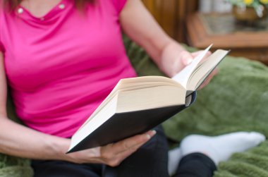 kadın bir kanepede kitap okuma