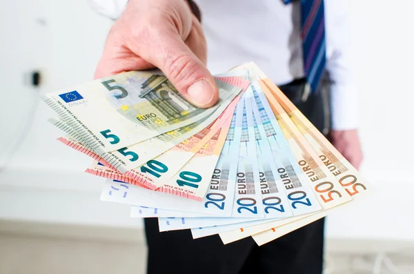 Mão de homem segurando notas de euro — Fotografia de Stock