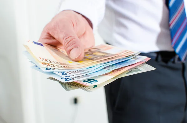 Mão de homem segurando notas de euro — Fotografia de Stock