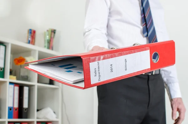 Empresario sosteniendo una carpeta roja — Foto de Stock