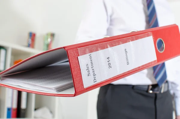 Бизнесмен держит красную папку — стоковое фото