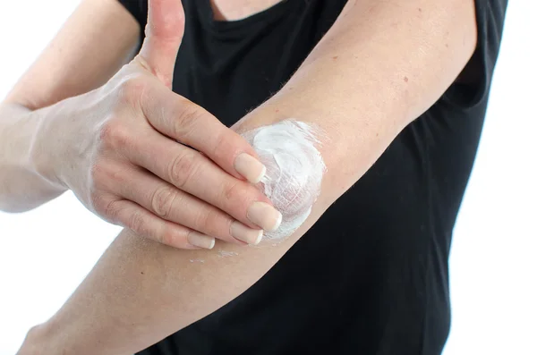 Woman putting cream on her elbow — Stock Photo, Image