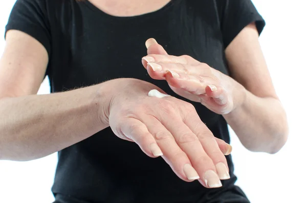 Donna mettendo crema sulla mano — Foto Stock