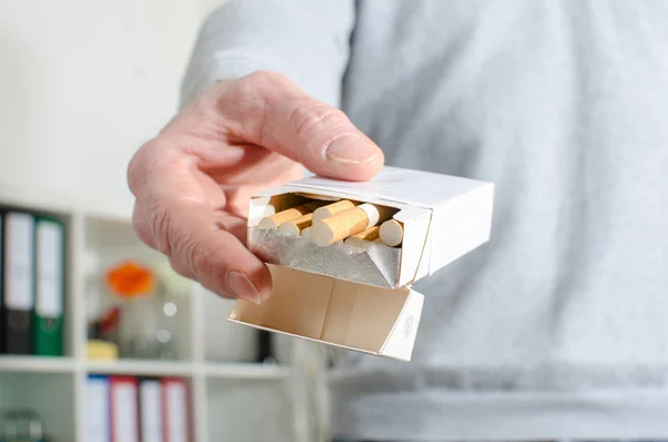 Man hand offering cigarettes — Stock Photo, Image