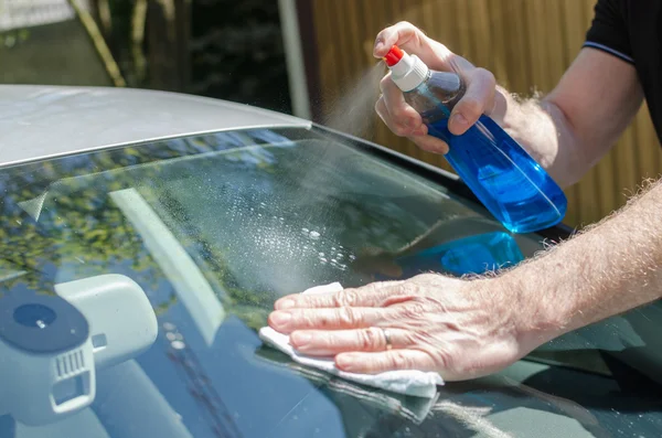 Чоловік чистить вітрове скло автомобіля — стокове фото