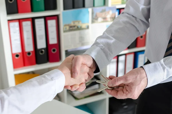 Mäklaren skakar hand med hans klient — Stockfoto