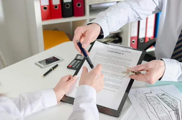 Makler gibt seinem Klienten einen Stift, um die Immobilie zu unterzeichnen — Stockfoto