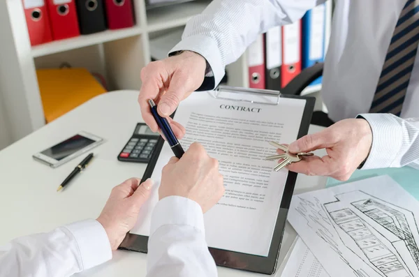 Realtor giving a pen to his client to sign the real estate contr — Stock Photo, Image