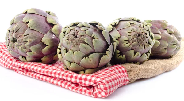 Fresh green purple artichokes on burlap — Stock Photo, Image