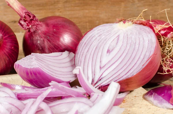 Cebollas rojas frescas en rodajas y enteras — Foto de Stock