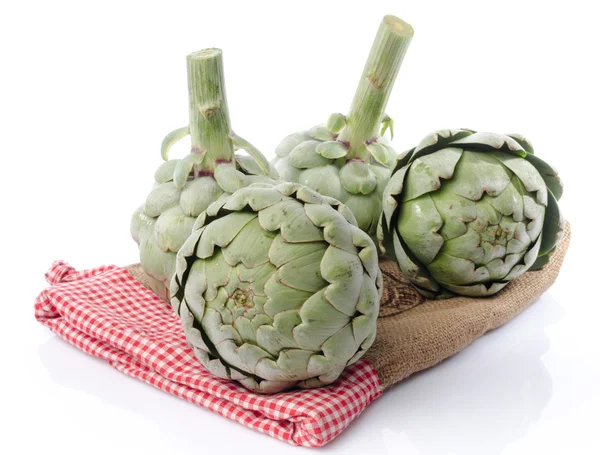 Fresh artichokes on burlap — Stock Photo, Image