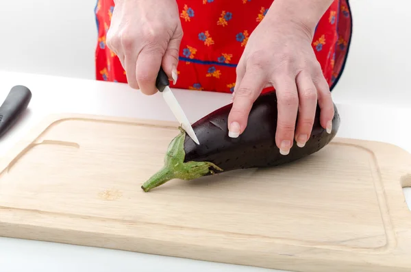 Mains de femme coupant aubergine — Photo