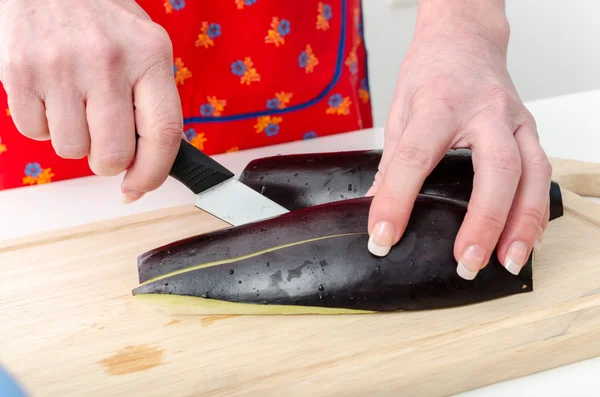 Handen van vrouw snijden aubergine — Stockfoto