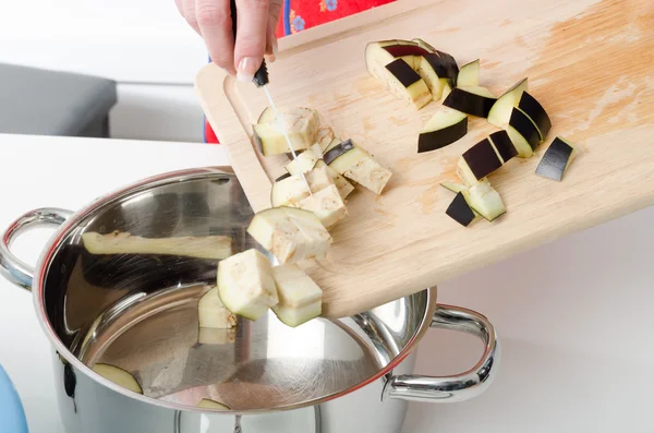 Ajouter des morceaux d'aubergine dans une casserole — Photo