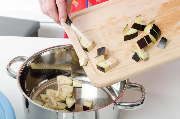 Toevoegen van aubergine stukken in steelpan — Stockfoto