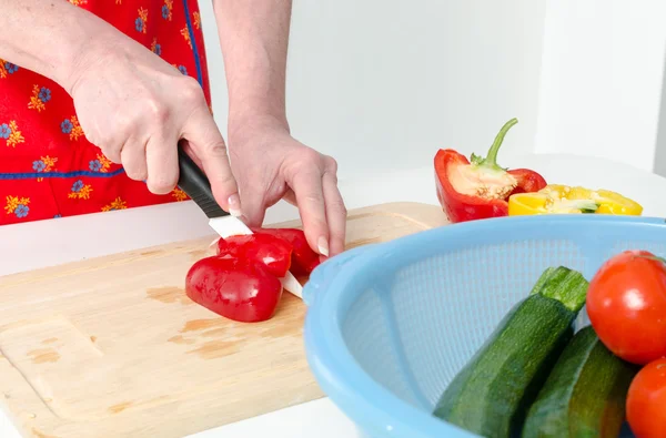 Händer kvinna skära röd paprika — Stockfoto