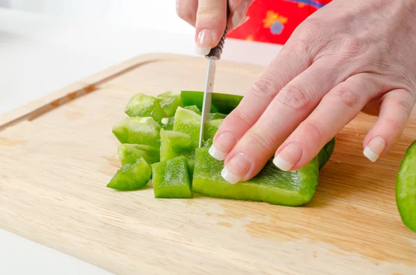 Handen van vrouw snijden groene peper — Stockfoto