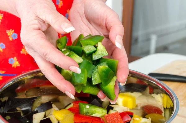 Att lägga grön paprika bitar i kastrull — Stockfoto