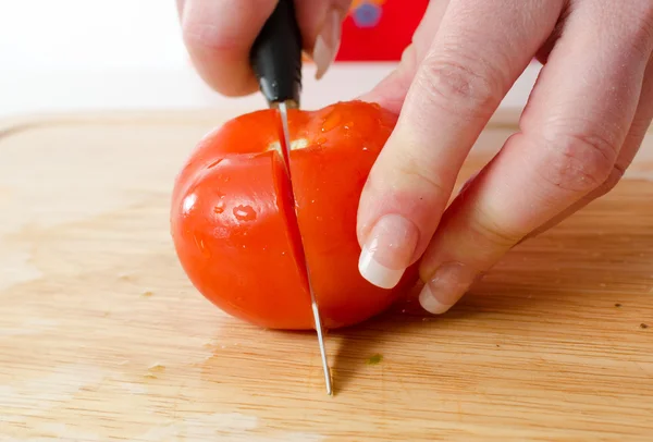 Hands of woman cutting tomato — Stock Photo, Image