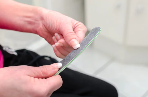 Mulher arquivando suas unhas — Fotografia de Stock