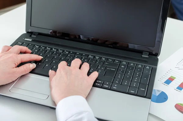 Businesswoman typing on a laptop — Stock Photo, Image