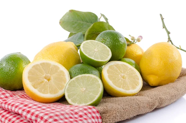 Limones y limones en una arpillera — Foto de Stock