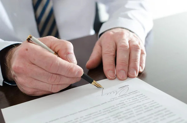 Affärsman som undertecknar ett dokument — Stockfoto