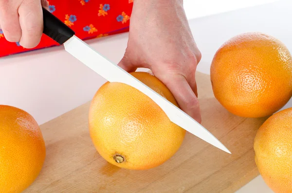 Vrouw snijden een grapefruit — Stockfoto