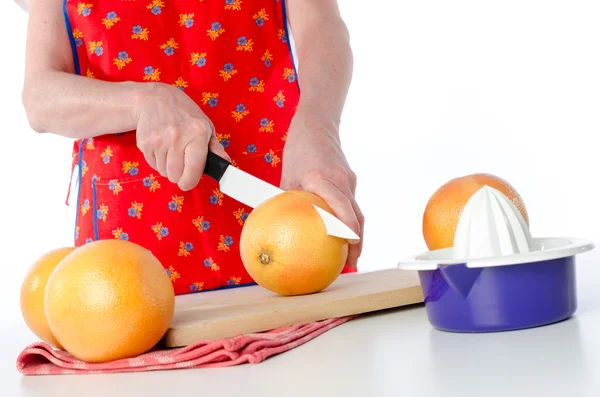 Frau schneidet eine Grapefruit — Stockfoto