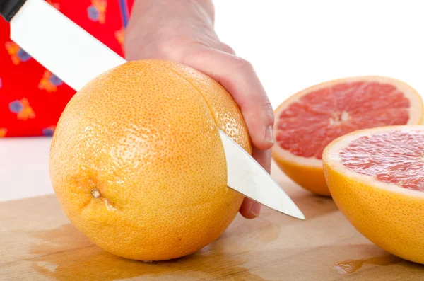 Женщина режет грейпфрут — стоковое фото