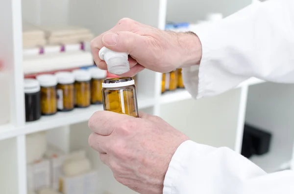 Hands opening a bottle of pills — Stock Photo, Image