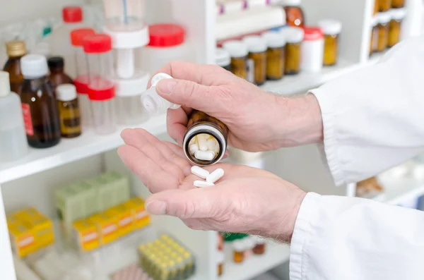 Doctor pouring medicine pills in hand — Stock Photo, Image