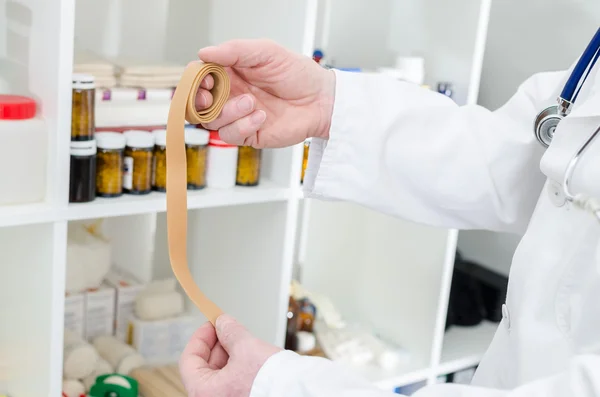 Doctor holding a latex tourniquet — Stock Photo, Image