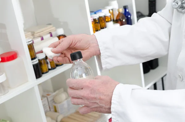 Läkaren håller en flaska desinfektionsmedel och en bit av bomull — Stockfoto