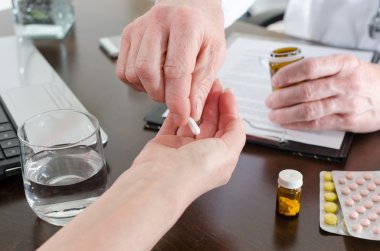 Doktor hastası için bir hap vererek