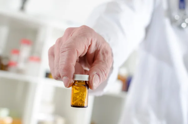 Médico mostrando un frasco de pastillas — Foto de Stock