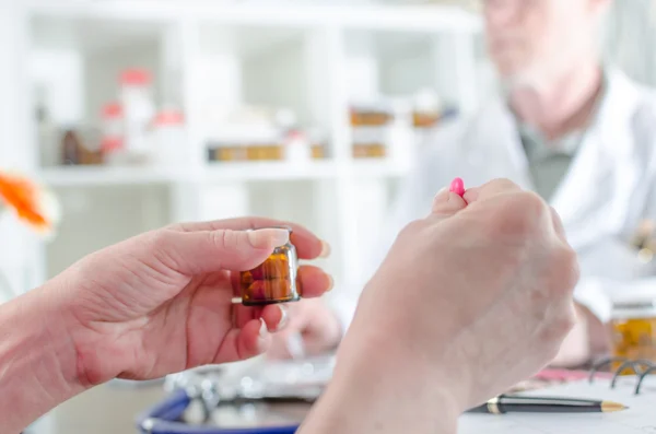 Patient tenant une pilule dans un cabinet médical — Photo