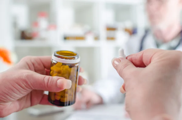 Patienten håller ett piller i medicinsk kontor — Stockfoto