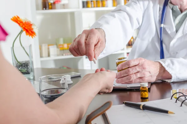 Doctor dando una píldora a su paciente — Foto de Stock