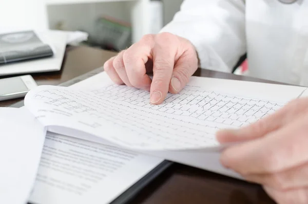 Doctor analyzing an electrocardiogram — Stock Photo, Image