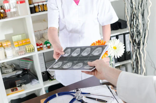 Asistente médico que entrega una resonancia magnética al médico — Foto de Stock