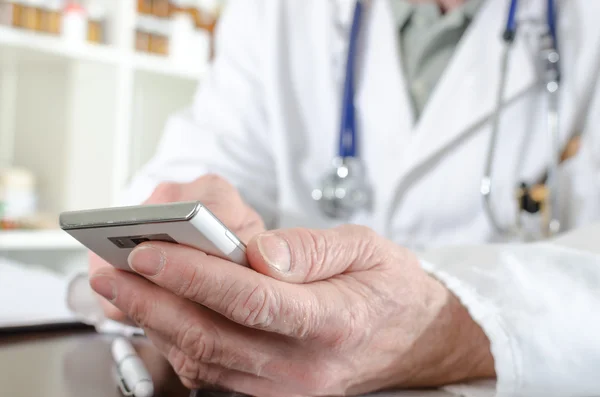 Doctor using his smartphone — Stock Photo, Image