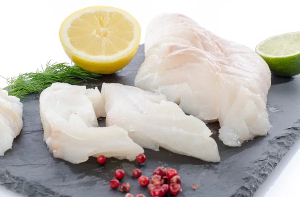 Fresh raw cod fillet on a slate plate — Stock Photo, Image