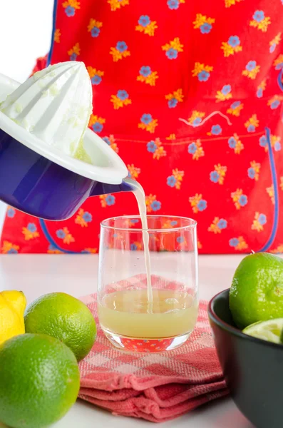 Mujer vertiendo jugo de limón en un vaso —  Fotos de Stock