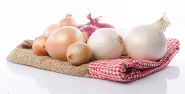 Different types of onions on burlap — Stock Photo, Image